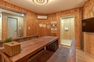 a dining room with a wooden table in a room at Gamsung Jeju Stay in Jeju