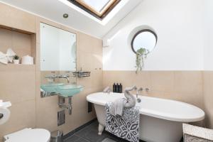 a bathroom with a sink and a tub and a mirror at Spacious & Charming 2BR - Perfect Stay in Northampton +19 photos
