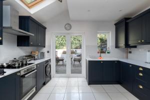 a kitchen with blue cabinets and a dining room at Spacious & Charming 2BR - Perfect Stay in Northampton