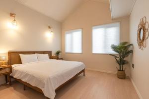 a bedroom with a bed and a potted plant at Jeju at Aewol Forest 402 in Jeju
