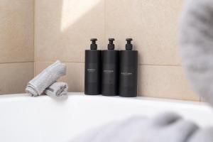 two black bottles sitting on a shelf in a bathroom at Spacious & Charming 2BR - Perfect Stay in Northampton