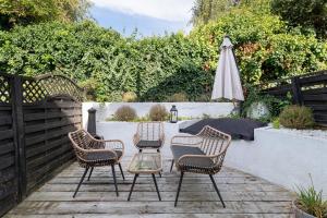 a patio with three chairs and a table and an umbrella at Spacious & Charming 2BR - Perfect Stay in Northampton