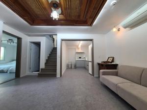 a living room with a couch and a staircase at Jeonju Pungnam Yangok in Jeonju