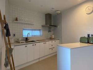 a kitchen with white cabinets and a counter top at Suncheon Stay Rev in Suncheon
