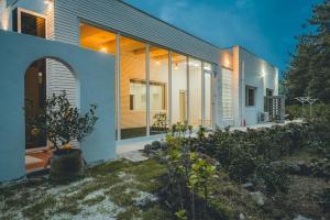 una casa con muchas ventanas a un lado. en Seogwipo Ojeju, en Seogwipo