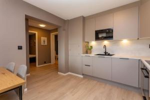 a kitchen with white cabinets and a wooden floor at 2 bedroom appartment - walking distance to the Technology Park, City Center & Uni - Fully furnished in Kongsberg +8 photos