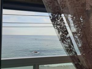 a view of the ocean from a window at Dream Pension in Yeongdeok