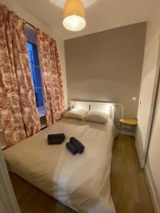 Un dormitorio con una cama con dos bolsas encima. en Château de Versailles 800m à pied, en Versalles