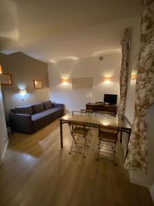 una sala de estar con una mesa y un sofá en Château de Versailles 800m à pied, en Versalles