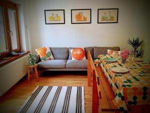 a living room with a table and a couch at Apartma Discovering Slovenia in Luče