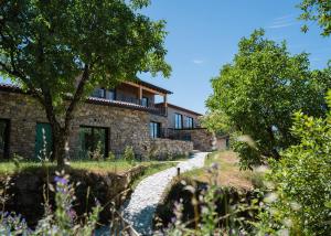 a stone house with a garden in front of it at Estrela Serenity - Mountain Resort in Folgosinho