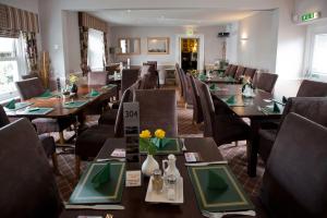 a restaurant with long tables and chairs with flowers on them at The Racehorses Hotel in Kettlewell