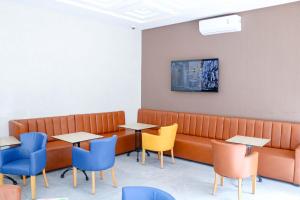 een wachtkamer met tafels en een bank en stoelen bij RESIDENCE MH HOTEL in Laayoune
