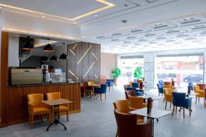 een restaurant met stoelen en tafels in een kamer bij RESIDENCE MH HOTEL in Laayoune