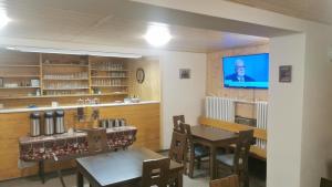 ein Esszimmer mit Tisch und Fernseher in der Unterkunft Hostel Fortuna in Špindlerův Mlýn