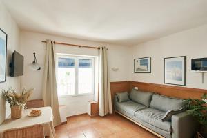 ein Wohnzimmer mit einer Couch und einem Fenster in der Unterkunft Horta III - Loft - Cadaqués in Cadaqués + 7 Fotos