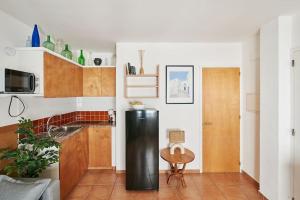 eine Küche mit einem schwarzen Kühlschrank und einem Tisch in der Unterkunft Horta III - Loft - Cadaqués in Cadaqués