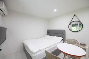 a room with a bed with a table and a mirror at Gapyeong Berry Berry Pension in Gapyeong