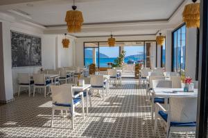 a restaurant with tables and chairs and a view of the ocean at Honeymoon Beach Otel in Marmaris