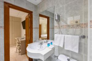 Un baño con un lavabo blanco y un espejo. en Hotel Sacromonte, en Granada