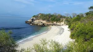 a white sandy beach next to the ocean at Suba Homestay in Nusa Lembongan