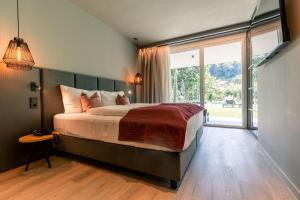 a bedroom with a large bed and a large window at Belia Lofts - ADULTS ONLY - Apartments in Appiano sulla Strada del Vino
