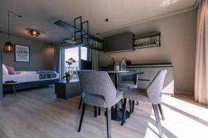 a kitchen and living room with a table and chairs at Belia Lofts - ADULTS ONLY - Apartments in Appiano sulla Strada del Vino