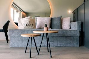 a living room with a couch and two tables at Belia Lofts - ADULTS ONLY - Apartments in Appiano sulla Strada del Vino