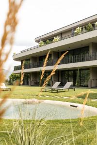 a building with benches and a pond in front of it at Belia Lofts - ADULTS ONLY - Apartments in Appiano sulla Strada del Vino