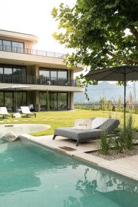 a swimming pool with a couch next to a building at Belia Lofts - ADULTS ONLY - Apartments in Appiano sulla Strada del Vino