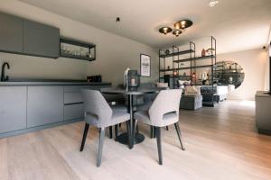 a kitchen and dining room with a table and chairs at Belia Lofts - ADULTS ONLY - Apartments in Appiano sulla Strada del Vino