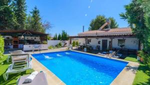 a swimming pool in front of a house at Grand Villa in Chimeneas, pool in Chimeneas