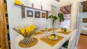 a dining room with a table with chairs and yellow flowers at Grand Villa in Chimeneas, pool in Chimeneas +24 photos