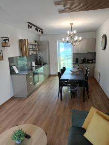 a dining room and living room with a table and a kitchen at Apartament Olchowa Prestige 3 in Ustroń