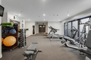 un gimnasio con varias cintas de correr y máquinas de cardio en City Hideaway 1 BR Apt with Pool and Gym, en Auckland