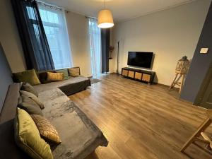 a living room with a couch and a flat screen tv at LFA - 167 - Agréable maison de village in Seraing