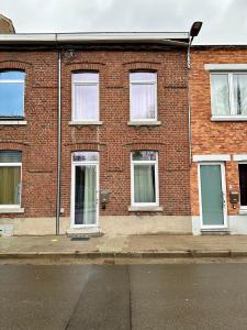 a red brick building with white windows and a street at LFA - 167 - Agréable maison de village in Seraing