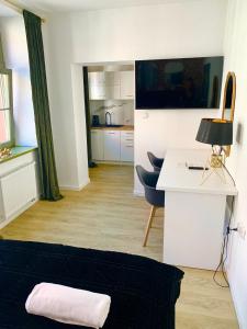 salon z biurkiem i kuchnią w obiekcie Apartamenty KB Toruń w Toruniu