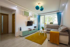 a living room with a couch and a tv at Perfect, relaxing and cozy apartment in Timişoara
