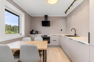 KongsbergにあるFully furnished apartment close to Technology park and Uniのテーブルと椅子と窓のあるキッチン +12枚の写真