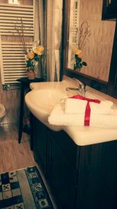 un bagno con lavandino bianco con un fiocco rosso di Trullo Sereno Angelo a Locorotondo