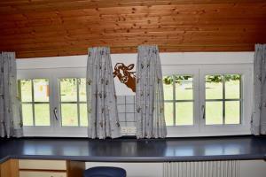 a dining room with windows and a table at Berghof Almzeit - Fewo "Heuboden", Sauna , Todtnauberg, Feldberg in Todtnau +30 photos