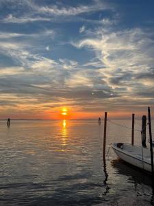 a boat is docked at a dock with the sunset at La casa di Alice in Venice