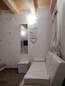a white living room with a couch and a mirror at La casa di Alice in Venice