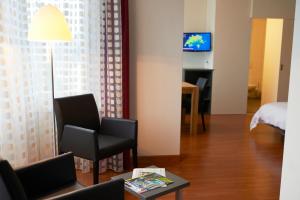 Televízia a/alebo spoločenská miestnosť v ubytovaní Congress Apartments by Hotel du Commerce