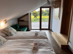 1 dormitorio con 1 cama grande y zapatillas. en Gajówka Pilica 45A, en Łęg Ręczyński