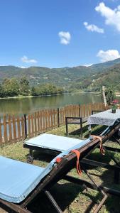 a picnic table next to a lake next to a fence at Vukova Brvnara in Drlače