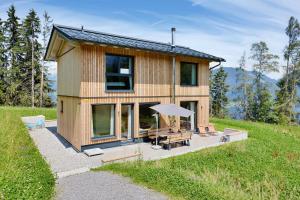 a tiny house on a hill with a table and an umbrella at Hus154 Ferienhaus im Brandnertal in Bürserberg