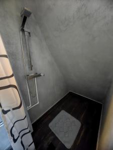 a bathroom with a shower with a wooden floor at La Fermă in Şeíca Mare