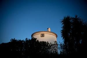 een toren met een boom voor een blauwe lucht bij Ha Mar ao Luar in Setúbal